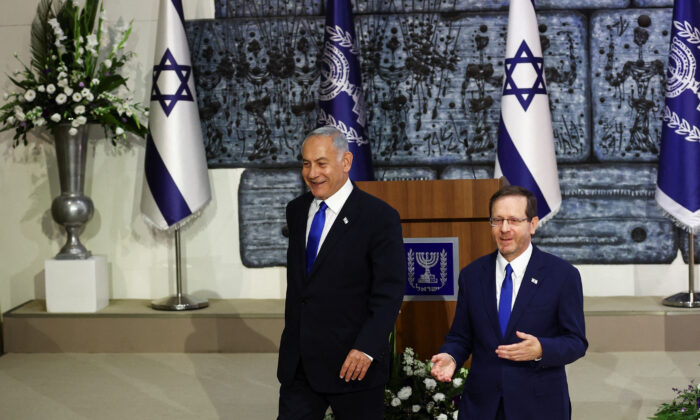以色列总统艾萨克·赫尔佐格 (Isaac Herzog) 在本杰明·内塔尼亚胡 (左) 旁边举行的仪式上，赫尔佐格 (Herzog) 向内塔尼亚胡 (Netanyahu) 授予在前总理右翼联盟于本月在耶路撒冷总统官邸举行的选举中获胜后组建新政府的任务。 2022 年 1 月 13 日。（Ronen Zvulun/路透社）