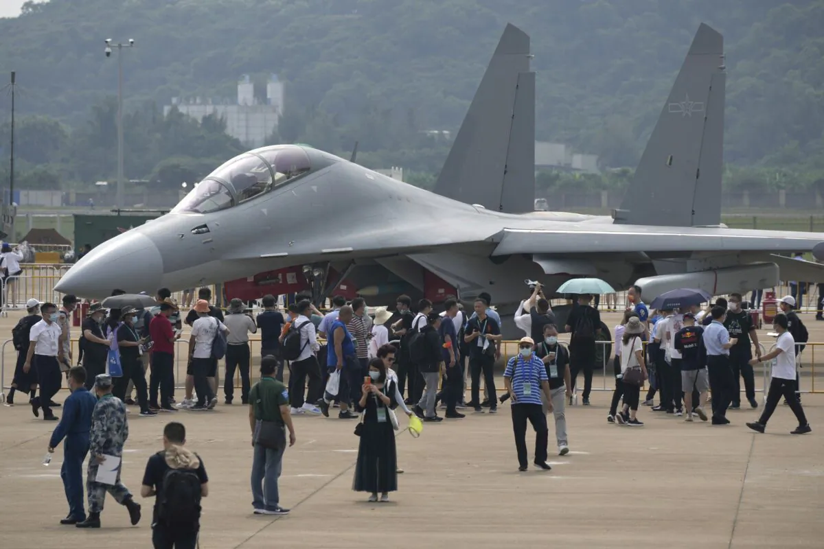 Visitors look at the J-16D electronic warfare variant of the Chinese military's J-16 airplane during 13th China International Aviation and Aerospace Exhibition, also known as Airshow China 2021 in Zhuhai, southern China, on Sept. 29, 2021. (Ng Han Guan/AP Photo)
