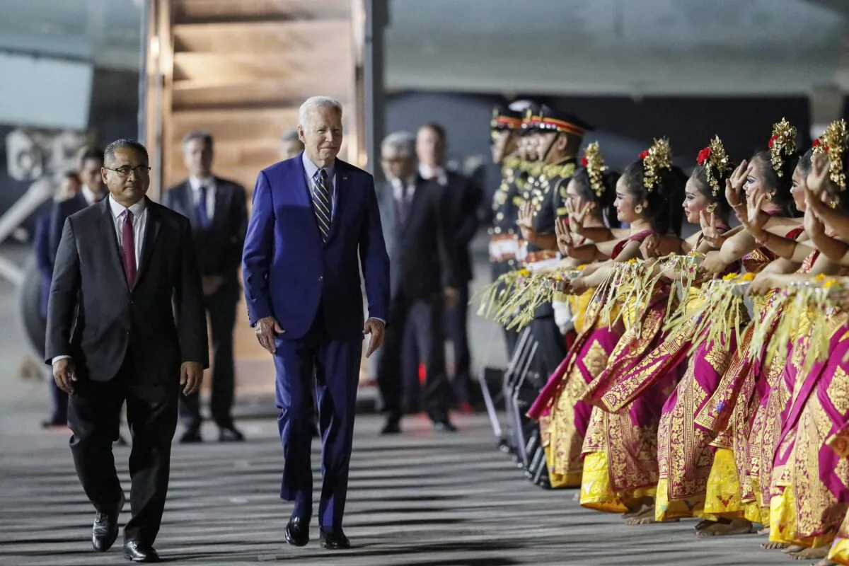 U.S. President Joe Biden walks as Balinese dancers perform during his arrival for the G20 summit at Ngurah Rai International airport in Bali, Indonesia, on Nov. 13, 2022. (Made Nagi/Pool via Reuters)