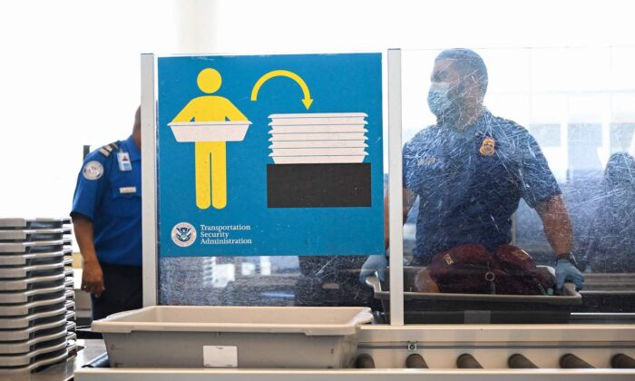 2022 年 8 月 10 日，一名运输安全管理局 (TSA) 特工在洛杉矶国际机场检查随身行李。（Patrick T. Fallon/AFP via Getty Images）
