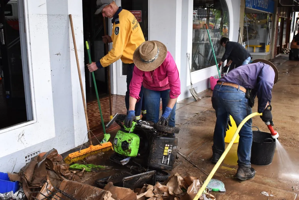 Volunteers and business owners remove debris from the central business district and clean up stock after flooding in the town of Molong, in the Central West region of New South Wales, Monday, November 14, 2022. (AAP Image/Murray McCloskey)