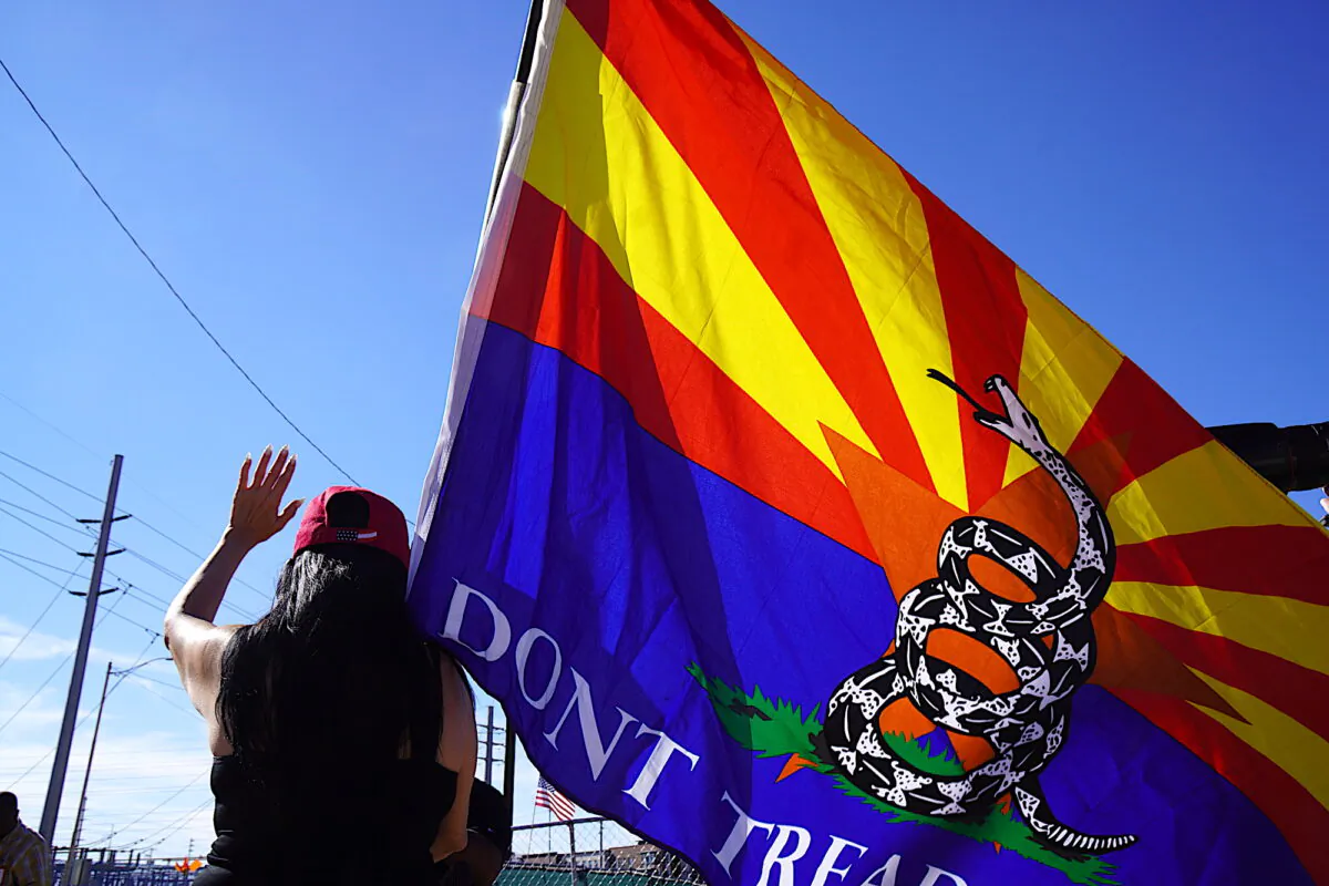 A woman holds an Arizona "Gadsden Flag" during an post-election prayer rally in Phoenix on Nov. 14, 2022. (Allan Stein/The Epoch Times)
