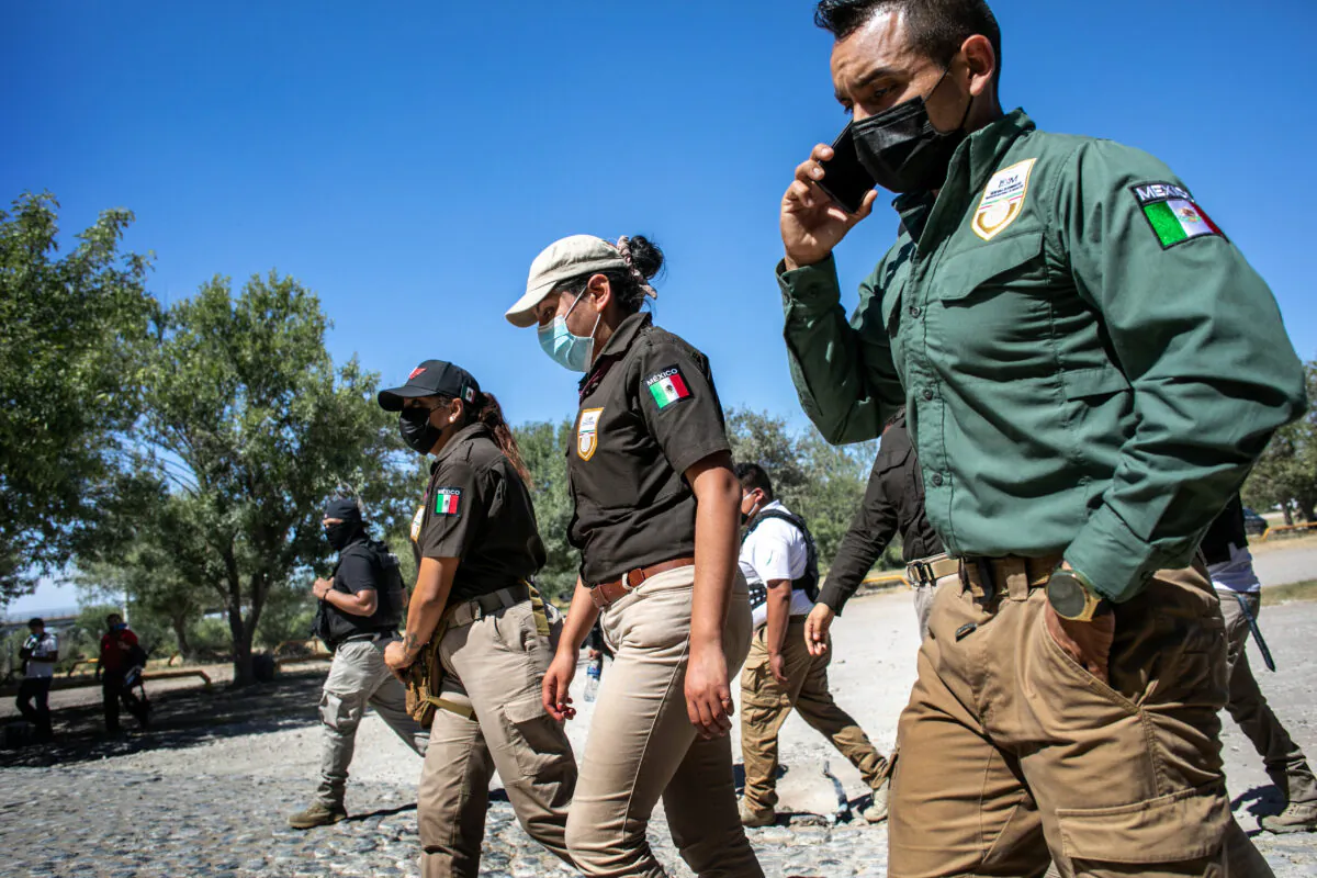 Mexican immigration officials walk to meet Haitian immigrants to stop them from crossing the U.S.-Mexico border in Ciudad Acuna, Mexico, on Sept. 23, 2021. (John Moore/Getty Images)