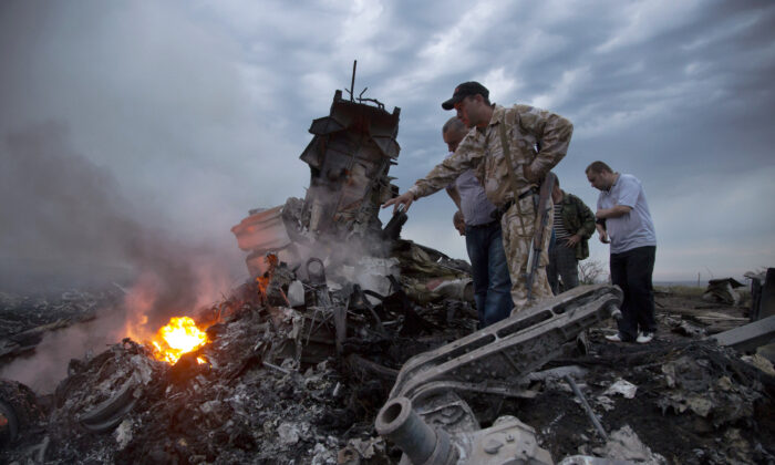 People inspect the crash site of a passenger plane near the village of Grabovo, Ukraine, on July 17, 2014. (Dmitry Lovetsky/AP Photo)