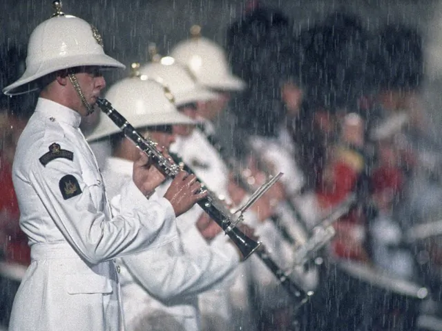 A member of Britain's Royal Marines Band play the clarinet in the pouring rain 30 June, 1997 during the British Military Farewell Ceremony marking the handover of Hong Kong to Chinese control. (Torsten Blackwood/AFP via Getty Images)