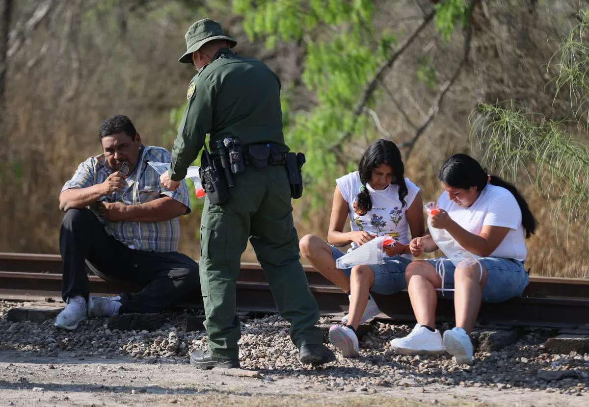 A Border Patrol agent processes people after they crossed the Rio Grande into Texas in Mission, Texas, on March 26, 2021. (Joe Raedle/Getty Images)