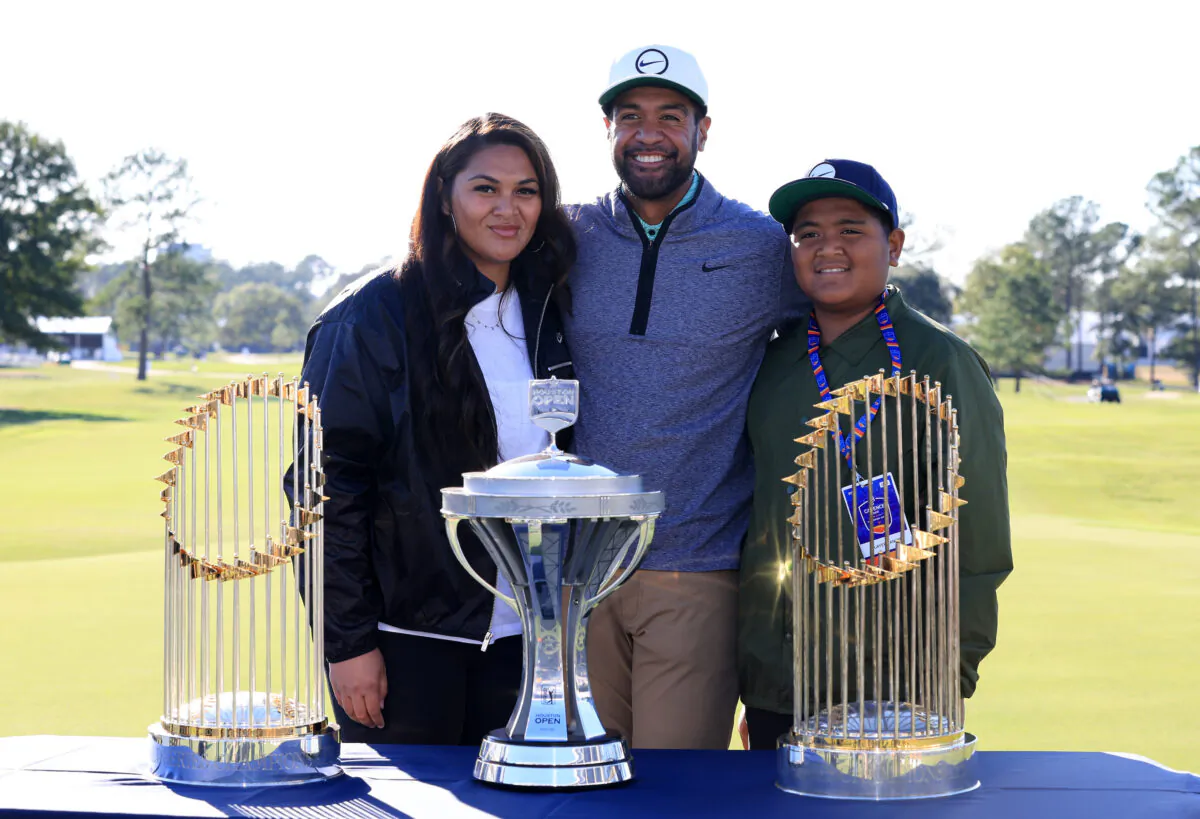 Tony Finau of the United States poses with the trophy and his wife Alayna and son Drace after putting in to win on the 18th hole during the final round of the Cadence Bank Houston Open at Memorial Park Golf Course in Houston, on Nov. 13, 2022. (Carmen Mandato/Getty Images)