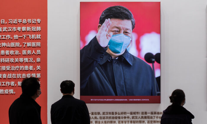 Zdjęcie chińskiego przywódcy Xi Jinpinga w masce jest wyświetlane w centrum kongresowym, które wcześniej było wykorzystywane jako prowizoryczny szpital dla pacjentów w Wuhan w Chinach, 15 stycznia 2021 r. (Nicolas Asfouri / AFP via Getty Images)