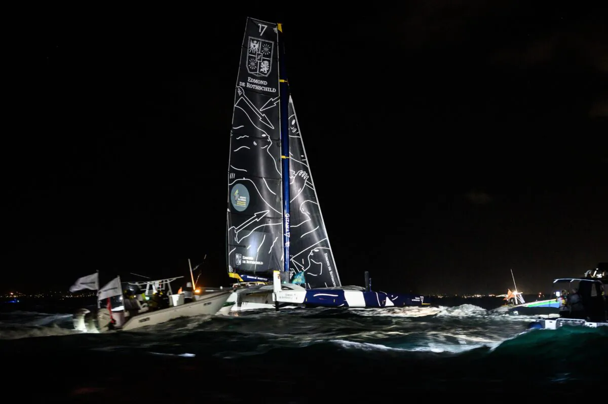Boats follow French skipper Charles Caudrelier onboard his Ultim multihull Gitana - Edmond de Rothschild, moments before crossing the finish line and win the Route du Rhum solo sailing race off Pointe-a-Pitre in the French west indies on Nov. 16, 2022. (Loic Venance/AFP via Getty Images)
