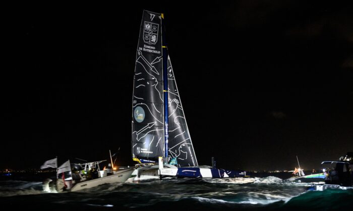 Boats follow French skipper Charles Caudrelier onboard his Ultim multihull Gitana - Edmond de Rothschild, moments before crossing the finish line and win the Route du Rhum solo sailing race off Pointe-a-Pitre in the French west indies on Nov. 16, 2022. (Loic Venance/AFP via Getty Images)