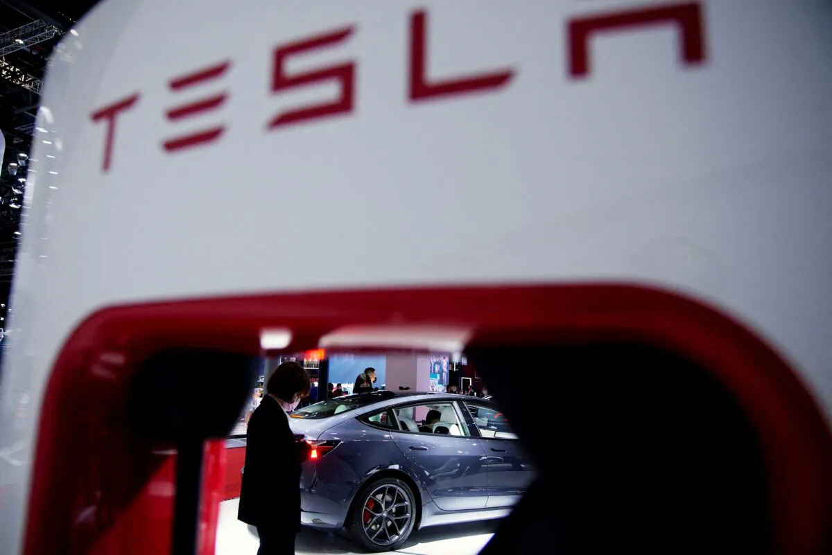 A Tesla electric vehicle (EV) is seen through a charging point displayed during a media day for the Auto Shanghai show in Shanghai on April 20, 2021. (Aly Song/Reuters)