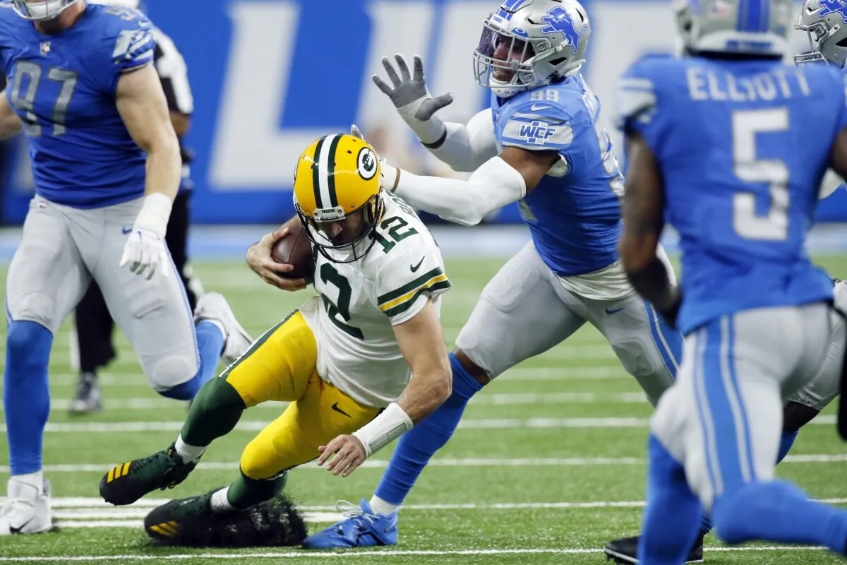Green Bay Packers quarterback Aaron Rodgers (12) slides as Detroit Lions linebacker Julian Okwara chases during the second half of an NFL football game in Detroit on Nov. 6, 2022. (Duane Burleson/AP Photo)