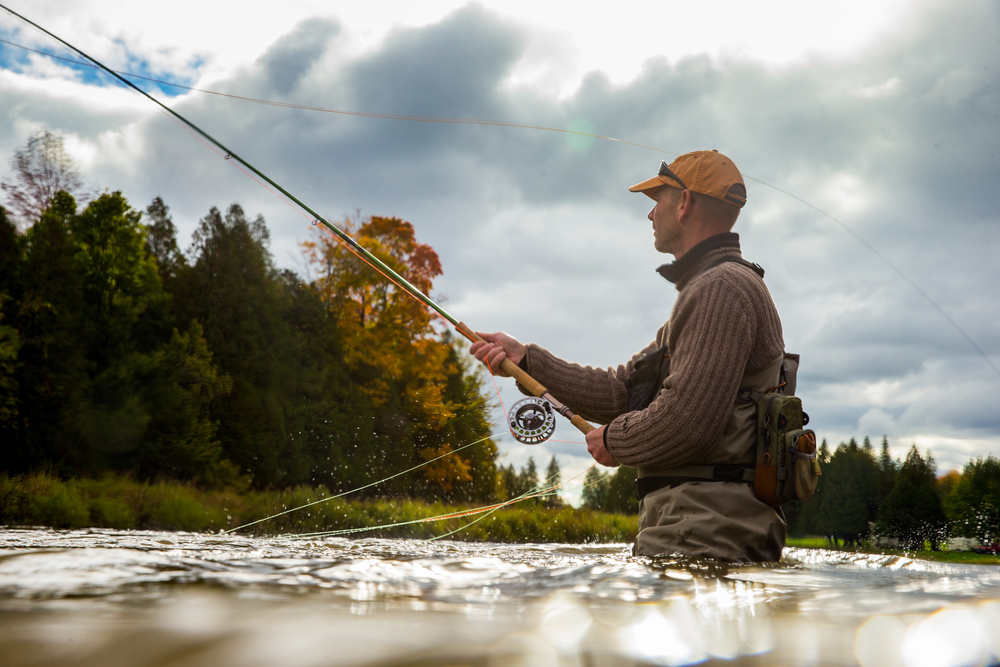 A,Man,Casts,His,Fly,Rod,Into,A,River,During