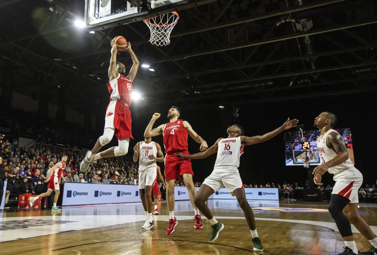 Canada's Jean-Victor Mukama (8) dunks as teammate Owen Klassen (4) and Panama's Eric Romero (16) react during second-half FIBA World Cup qualifiers basketball game action in Edmonton, Alberta, Canada, on Nov. 13, 2022. (Jason Franson/The Canadian Press via AP)