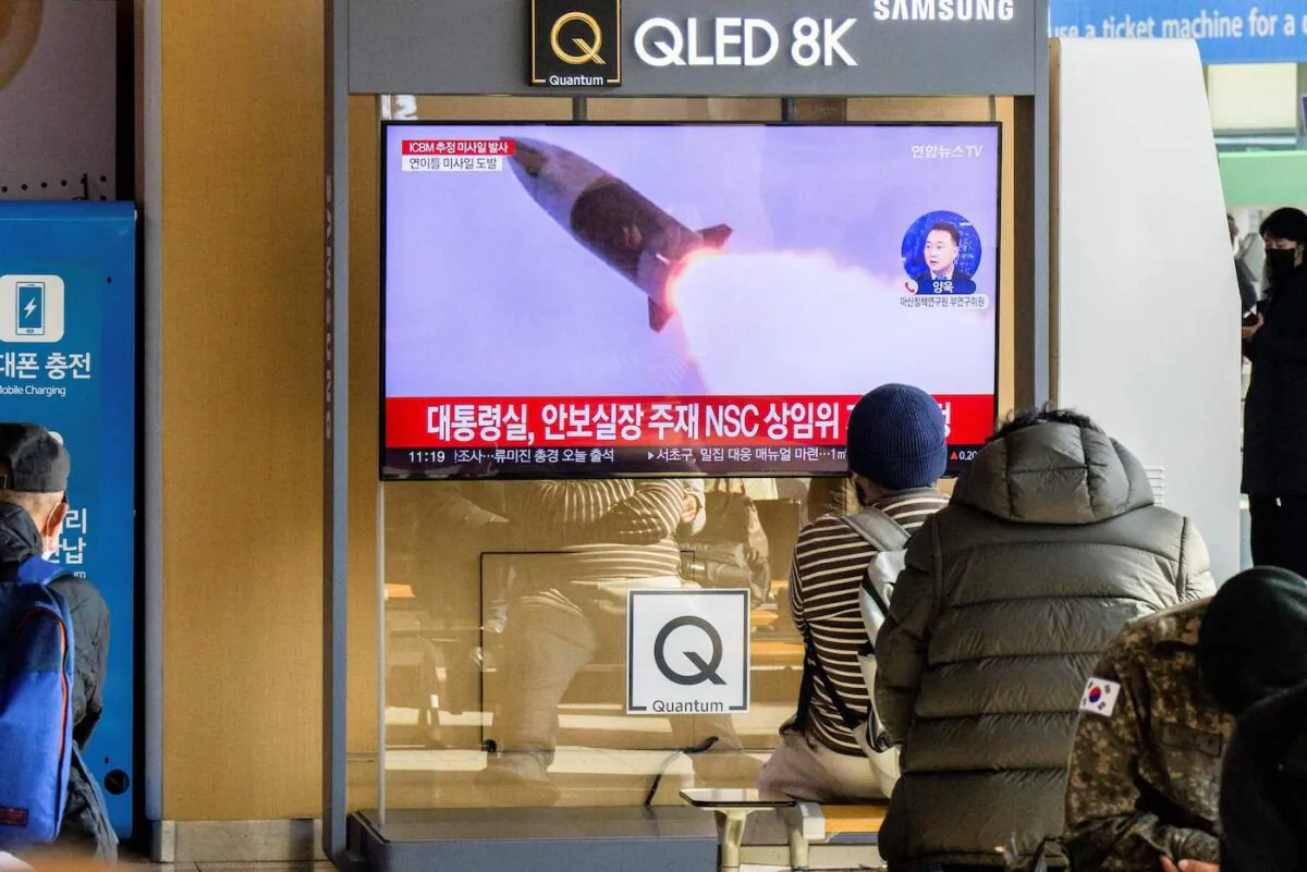 People sit near a television showing a news broadcast with file footage of a North Korean missile test, at a railway station in Seoul on Nov. 18, 2022. (Anthony Wallace/AFP via Getty Images)