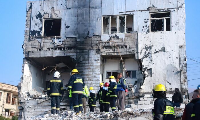 2022 年 11 月 18 日，在伊拉克北部城市苏莱曼尼亚，人们聚集在一座因油箱爆炸后倒塌的建筑物的废墟下寻找受害者和幸存者。（Shwan Mohammed/AFP via Getty Images）