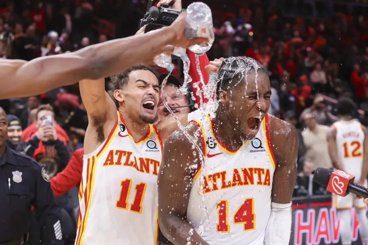 Atlanta Hawks guard Trae Young (11) dumps water on forward AJ Griffin (14) after an overtime victory against the Toronto Raptors at State Farm Arena in Atlanta on Nov. 19, 2022. (Brett Davis-USA TODAY Sports via Field Level Media)