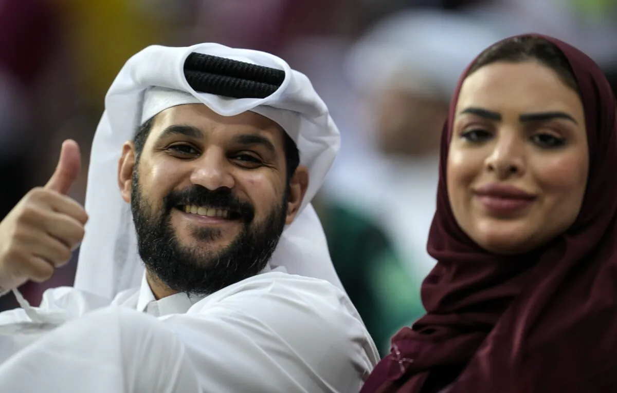 A couple on the tribune smiles to the camera prior the World Cup, group A soccer match between Qatar and Ecuador at the Al Bayt Stadium in Doha, Qatar, on Nov. 20, 2022. (Natacha Pisarenko/AP Photo)