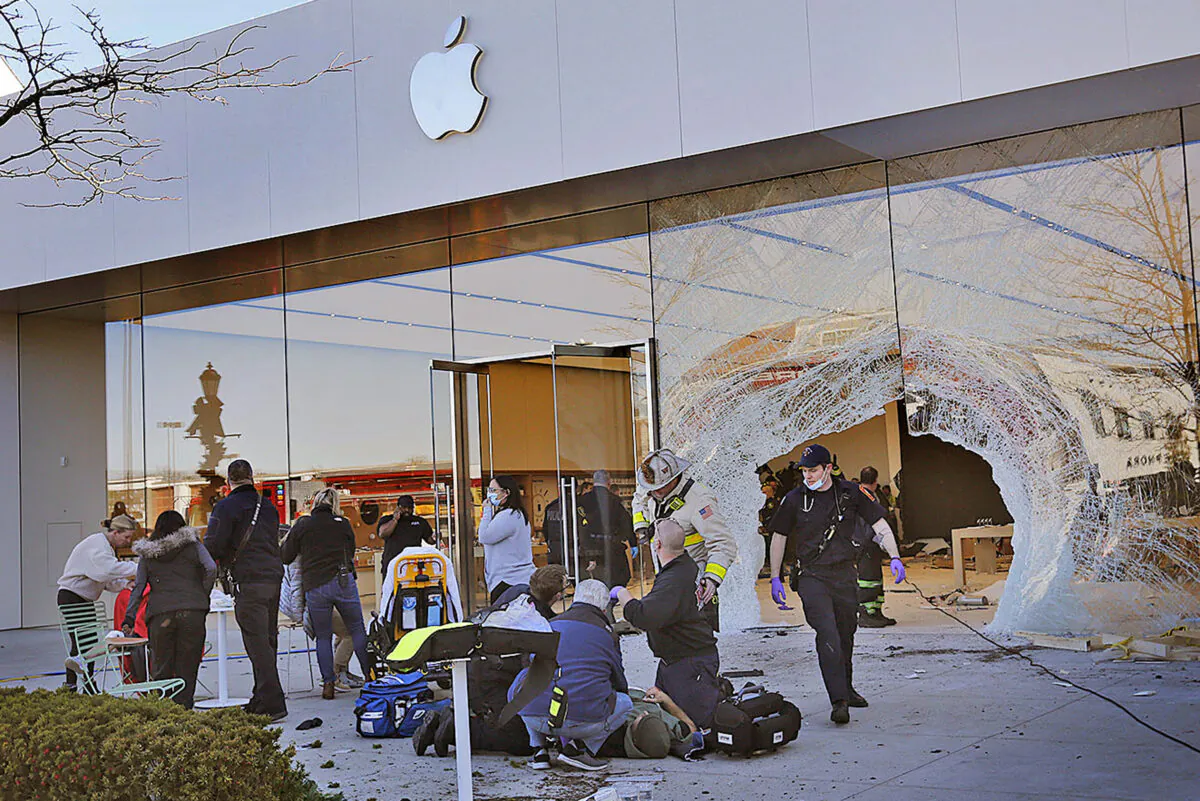 Emergency workers aid injured shoppers after an SUV drove into an Apple store in Hingham, Mass., on Nov. 21, 2022. (Greg Derr/The Patriot Ledger via AP)