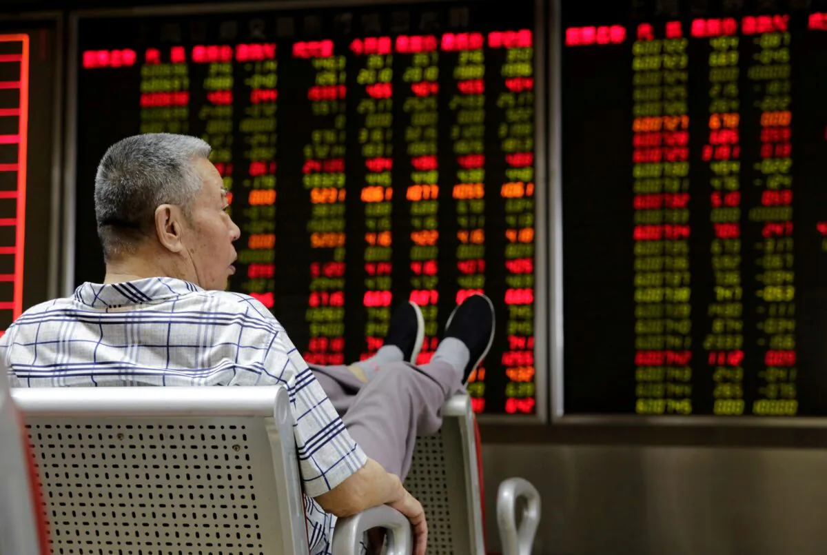 An investor watches stock prices at a brokerage office in Beijing, China, on July 6, 2018. (Jason Lee/Reuters)