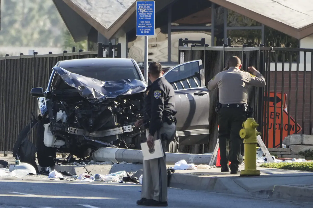 Two investigators stand next to a mangled SUV that struck Los Angeles County sheriff's recruits in Whittier, Calif., on Nov. 16, 2022. (Jae C. Hong/AP Photo)