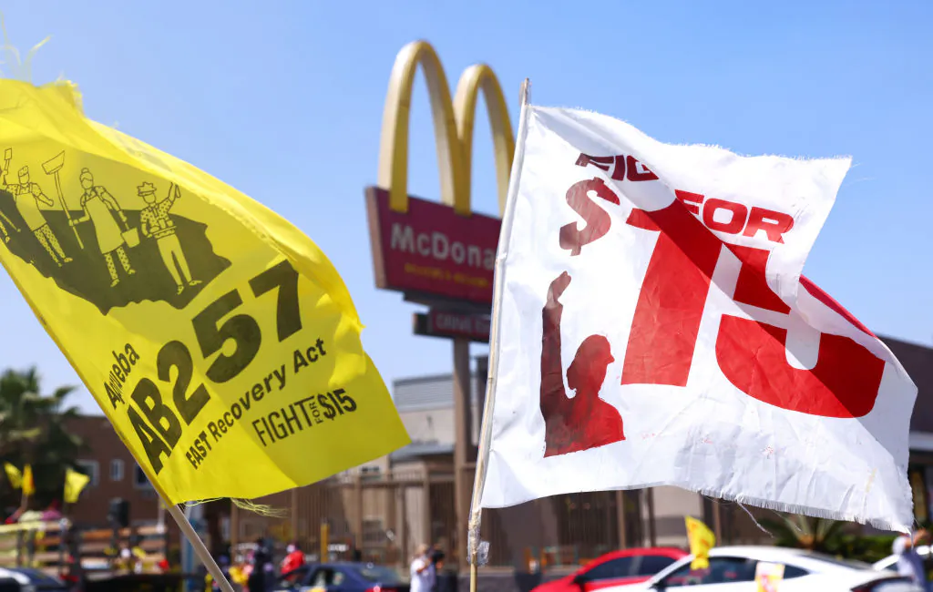 Flags are flown at a car caravan and rally of fast-food workers and supporters for passage of Assembly Bill 257, a fast-food worker health and safety bill, in the Boyle Heights neighborhood of Los Angeles on April 16, 2021. (Mario Tama/Getty Images)