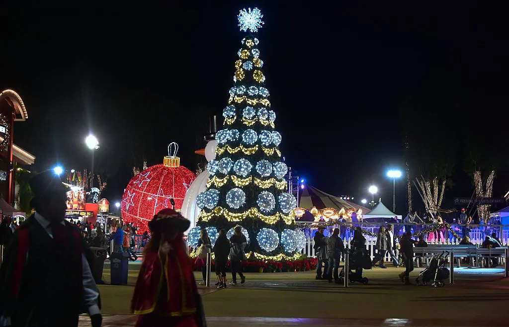 People walk past the lit Christmas tree at Winterfest in Costa Mesa, Calif., on Dec. 19, 2016. (Frederic J. Brown/AFP via Getty Images)