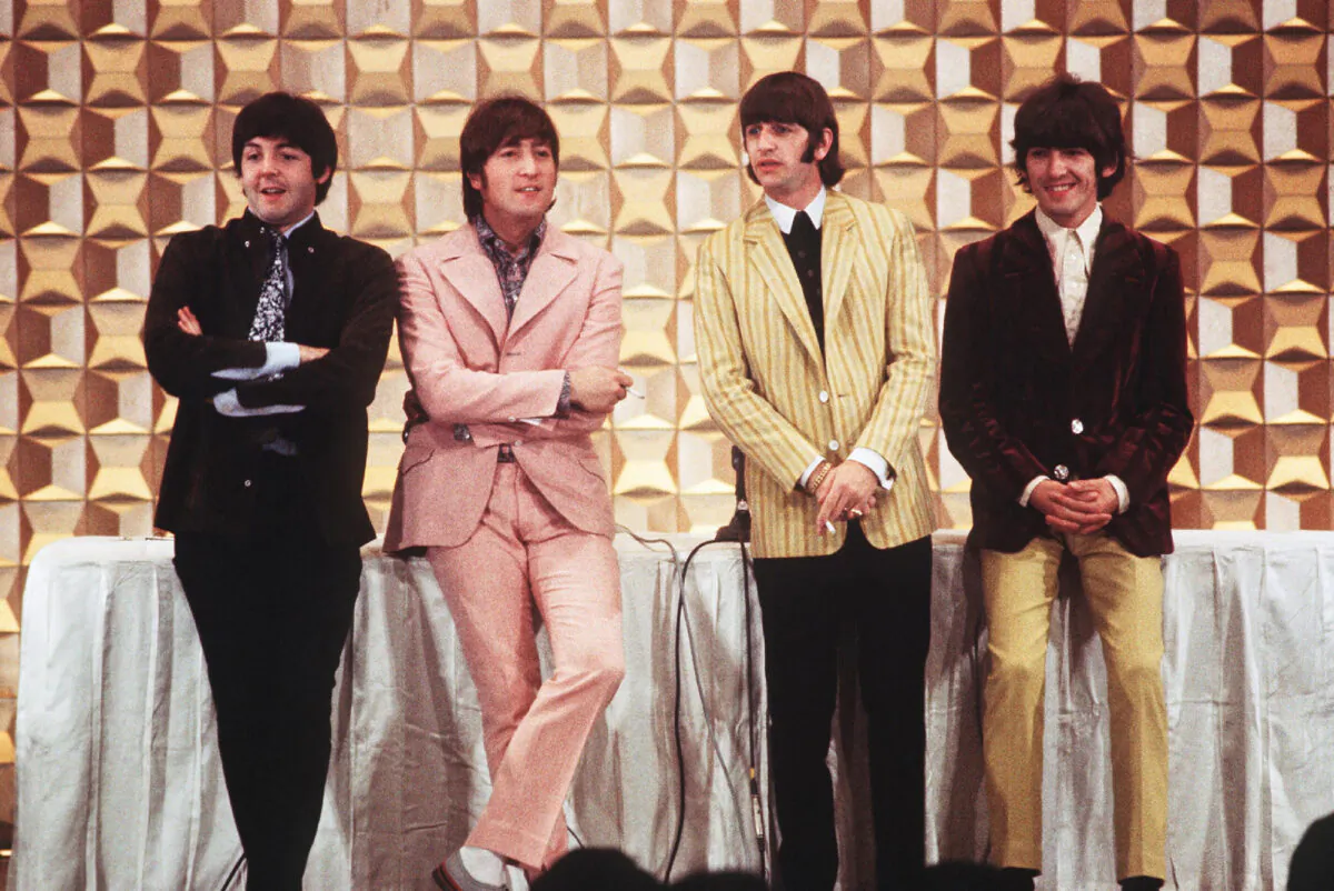 (L–R) Members of the British band The Beatles Paul McCartney, John Lennon, Ringo Starr, and George Harrison hold a press conference in Tokyo on June 29, 1966. (Jiji Press/AFP via Getty Images)