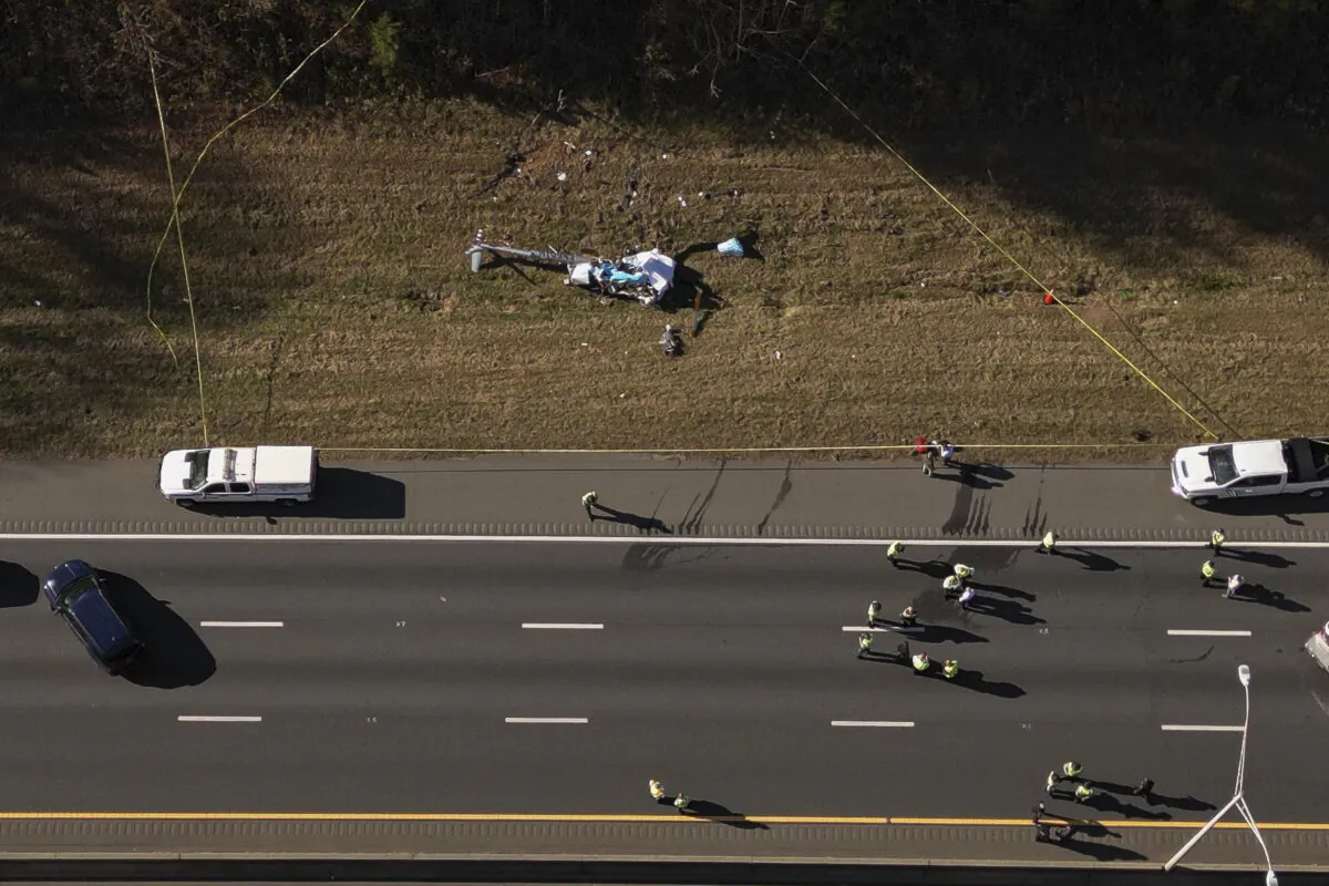 Emergency personnel work at the scene of a helicopter crash on the side of Interstate 77 South in Charlotte, N.C., on Nov. 22, 2022. (Alex Slitz/The Charlotte Observer via AP)