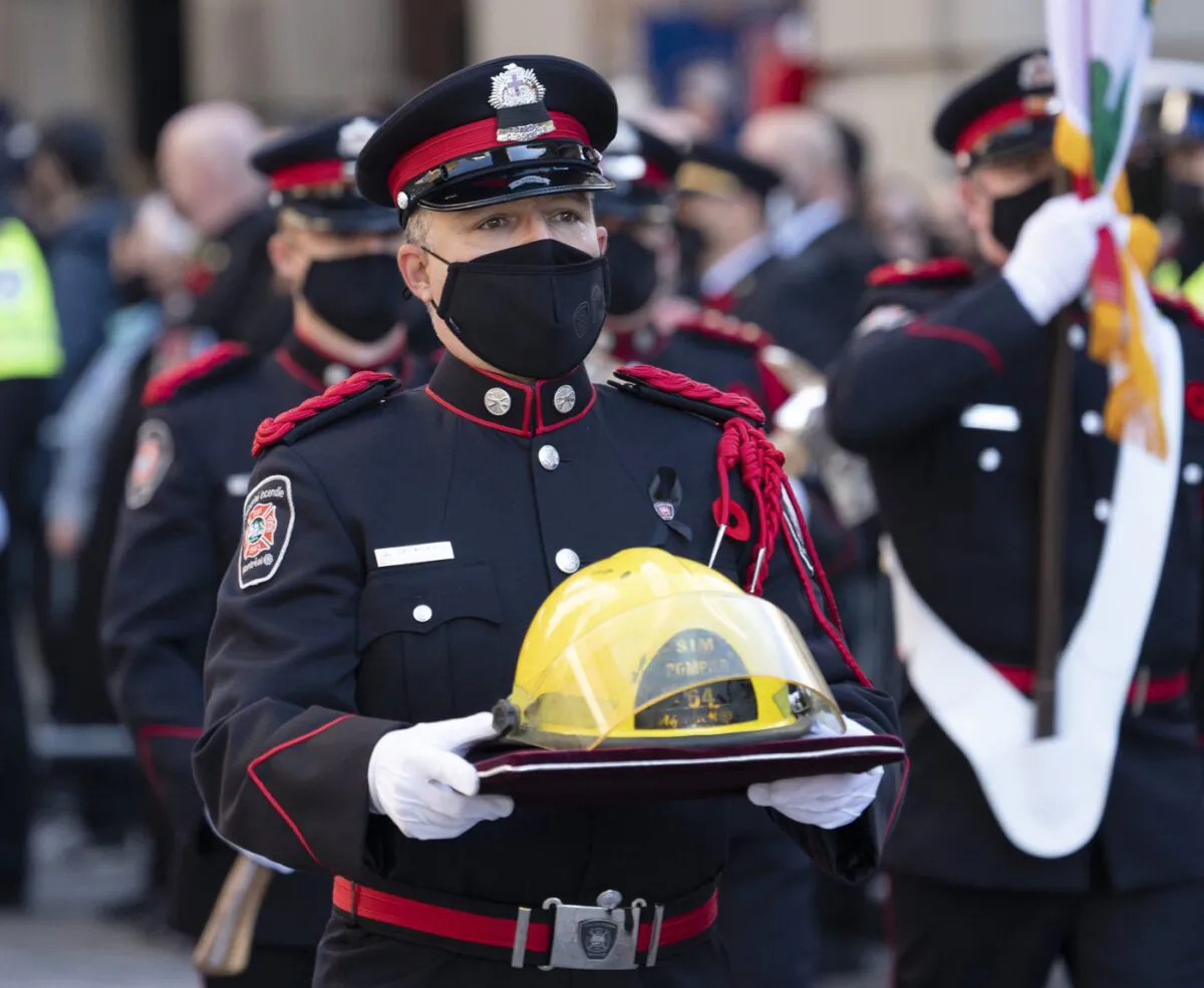 The helmet of fireman Pierre Lacroix is carried to the church for his funeral services in Montreal, Oct. 29, 2021. (The Canadian Press/Ryan Remiorz)