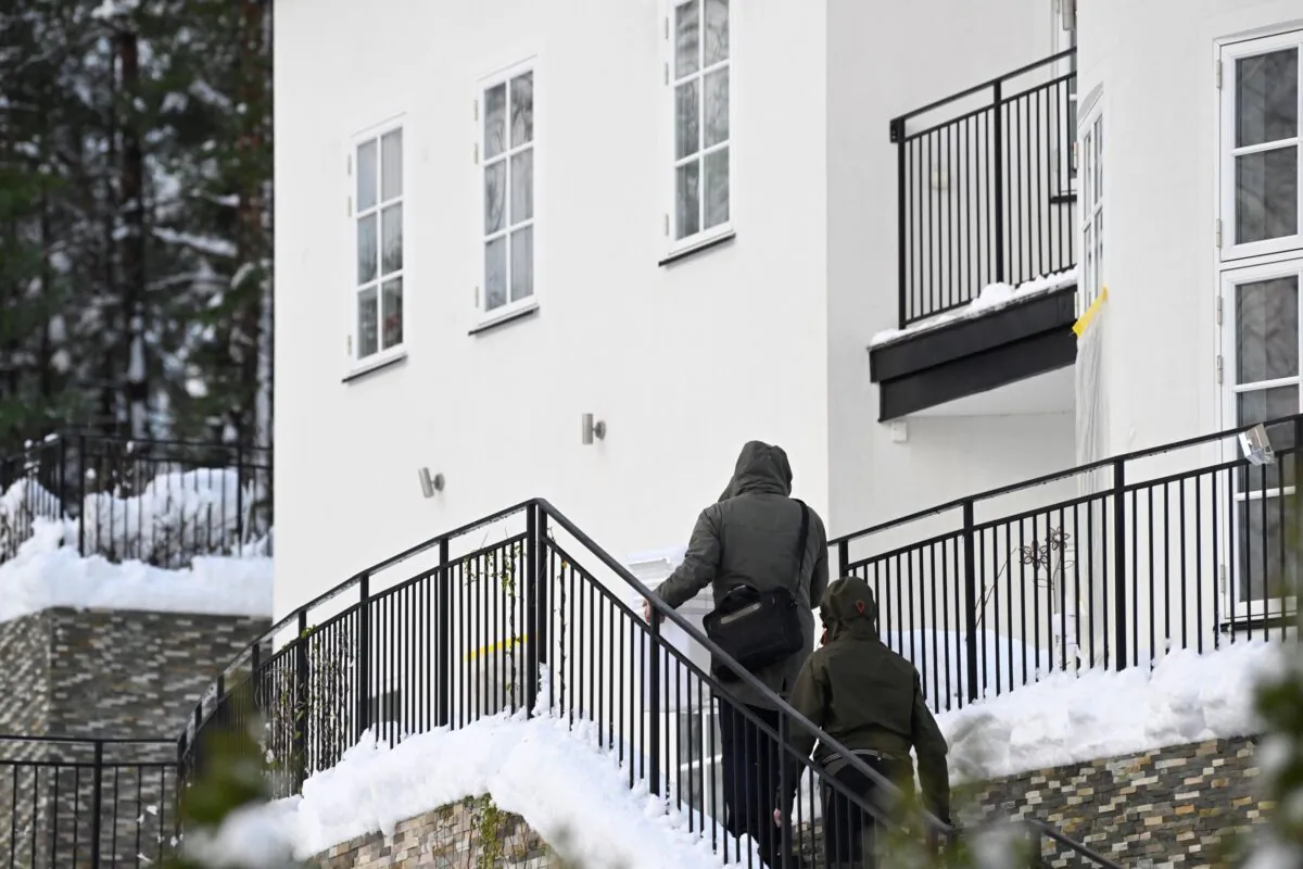 Two unidentified people approaching a house where the Swedish Security Service allegedly arrested two people on suspicions of espionage in a predawn operation in Stockholm on Nov. 22, 2022. (Fredrik Sandberg/TT News Agency via AP)