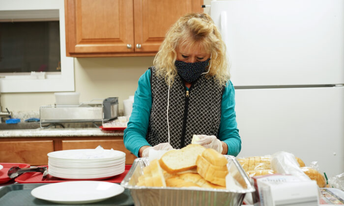 A volunteer prepares dinner for guests at Middletown Warming Station in Middletown, N.Y., on Nov. 20, 2022. (Cara Ding/The Epoch Times)