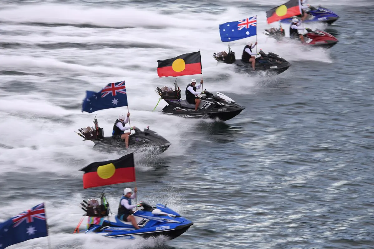 Jetski’s fly the Australian and Aboriginal flags during Australia Day celebrations at Circular Quay, in Sydney, Australia, on Jan. 26, 2021. (AAP Image/Dan Himbrechts)
