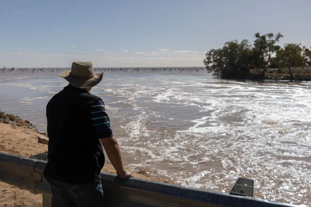 A person watches water flowing into Lake Pamamaroo on May 17, 2021 in Menindee, Australia. (Photo by Brook Mitchell/Getty Images)