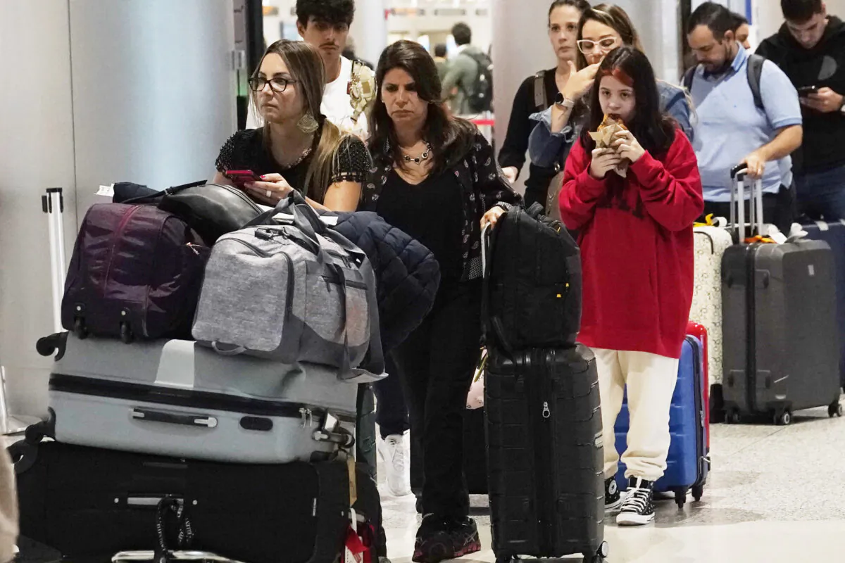 Travelers wait in a long line to check their luggage for a LATAM flight in Miami, on Nov. 21, 2022. (Marta Lavandier/AP Photo)