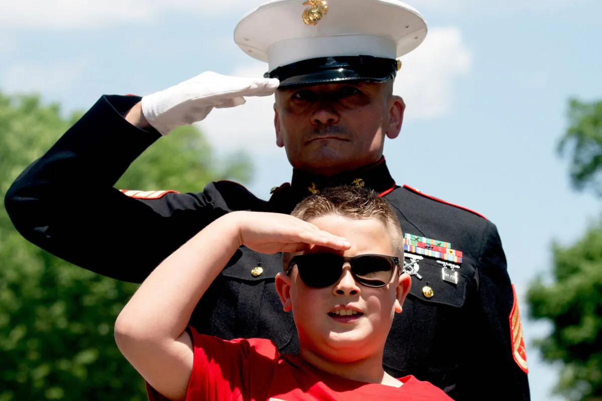 Jackson Leonard, the eight-year-old son of a US Marine, salutes as motorcyclists in the Rolling to Remember ride pass near the Lincoln Memorial in Washington, D.C., on May 29, 2022. (Stefani Reynolds/Getty Images)