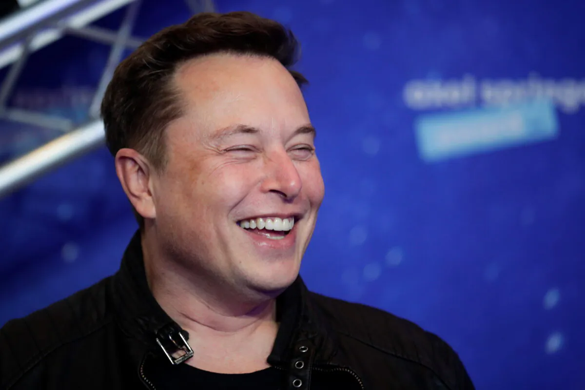 SpaceX owner and Tesla CEO Elon Musk laughs as he arrives on the red carpet for the Axel Springer Awards ceremony, in Berlin, on Dec. 1, 2020. (Hannibal Hanschke/AFP via Getty Images)