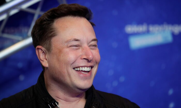 SpaceX owner and Tesla CEO Elon Musk laughs as he arrives on the red carpet for the Axel Springer Awards ceremony, in Berlin, on Dec. 1, 2020. (Hannibal Hanschke/AFP via Getty Images)