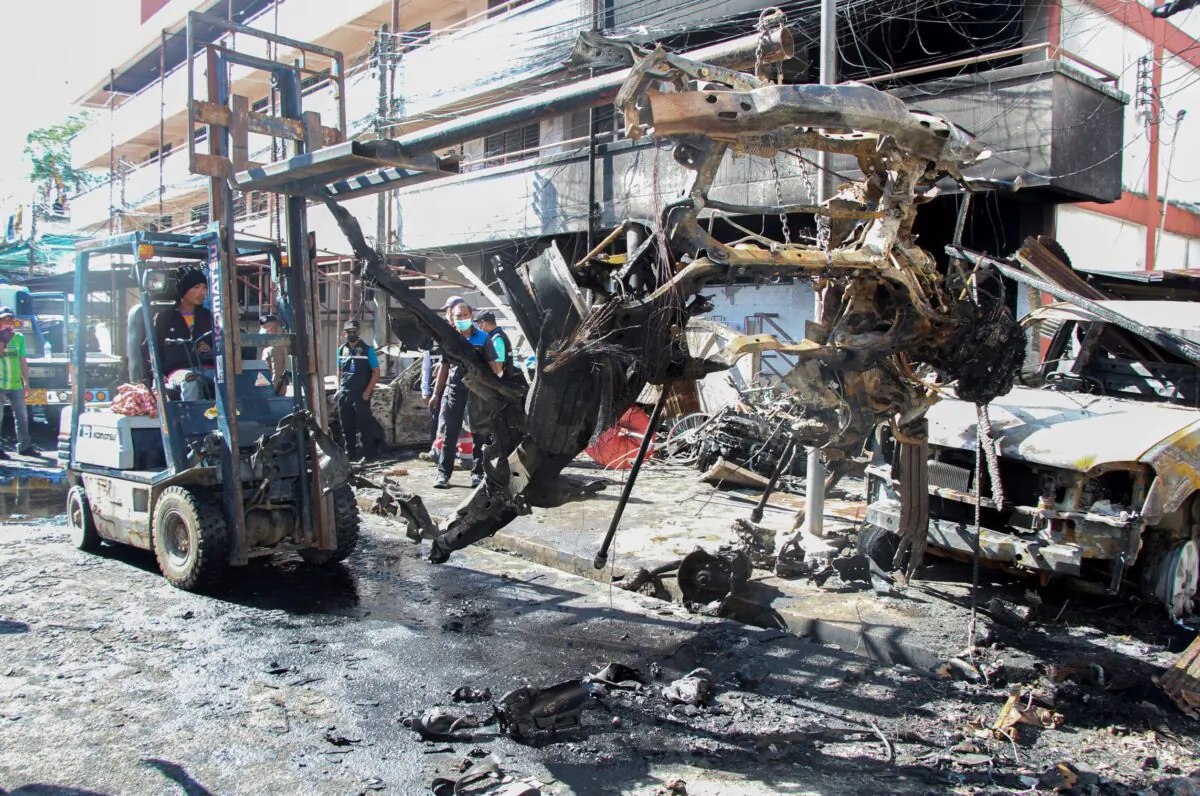 A worker moves wreckage of a car damaged by an explosion in Narathiwat province, southern Thailand, on Nov. 23, 2022. (Kriya Tehtan/AP Photo)