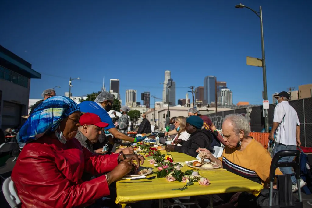 Homeless people eat the Thanksgiving meal served by the nonprofit Midnight Mission to nearly 2,000 homeless people in the Skid Row neighborhood of downtown Los Angeles on Nov. 25, 2021. (Apu Gomes/AFP via Getty Images)