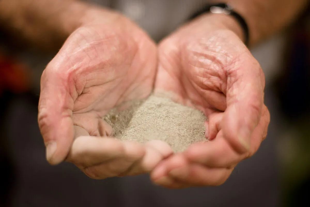 Mike Proudfoot, CEO of Marine Minerals Limited, holds a sample of tin-rich sea-bed sediment at the testing facility at the former Wheal Jane mine, near Truro in Cornwall, southwestern England, on Aug. 7, 2013. (Leon Neal/AFP via Getty Images)