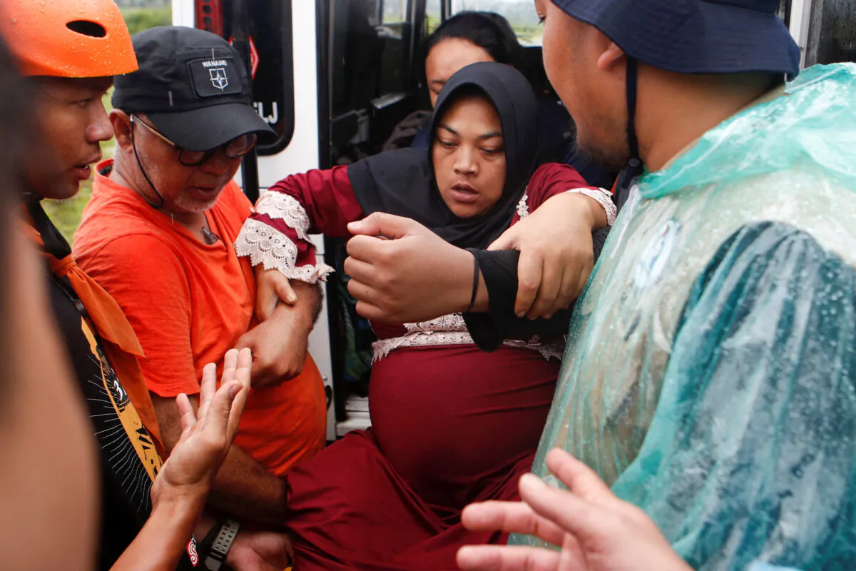 Rohmat Kartini, 35, a pregnant woman, is evacuated to a relief centre after an earthquake hit Sukamulya, in Cianjur, West Java Province, Indonesia, on Nov. 23, 2022. (Ajeng Dinar Ulfiana/Reuters)