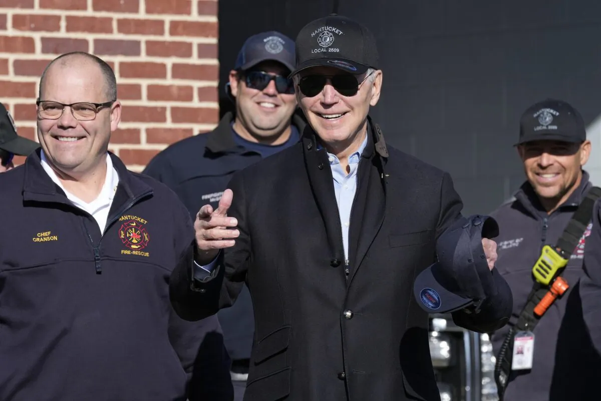 President Joe Biden (C) standing next to Nantucket Fire Department Chief Michael Cranson (L) talks during a visit with firefighters on Thanksgiving Day at the Nantucket Fire Department in Nantucket, Mass., on Nov. 24, 2022. (Susan Walsh/AP Photo)