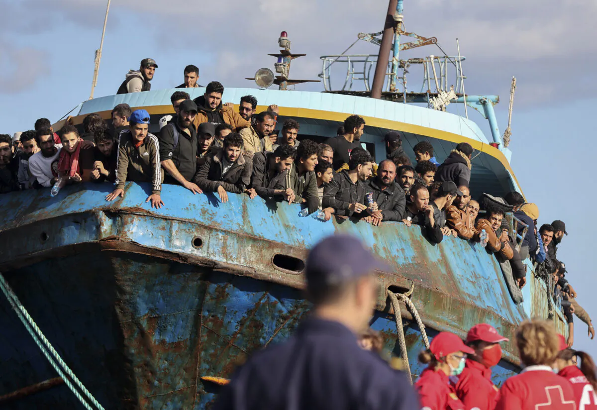 Migrants look out of a fishing boat docked at the port of Palaiochora in southeastern Crete, Greece on Nov. 22, 2022. (InTime News via AP)