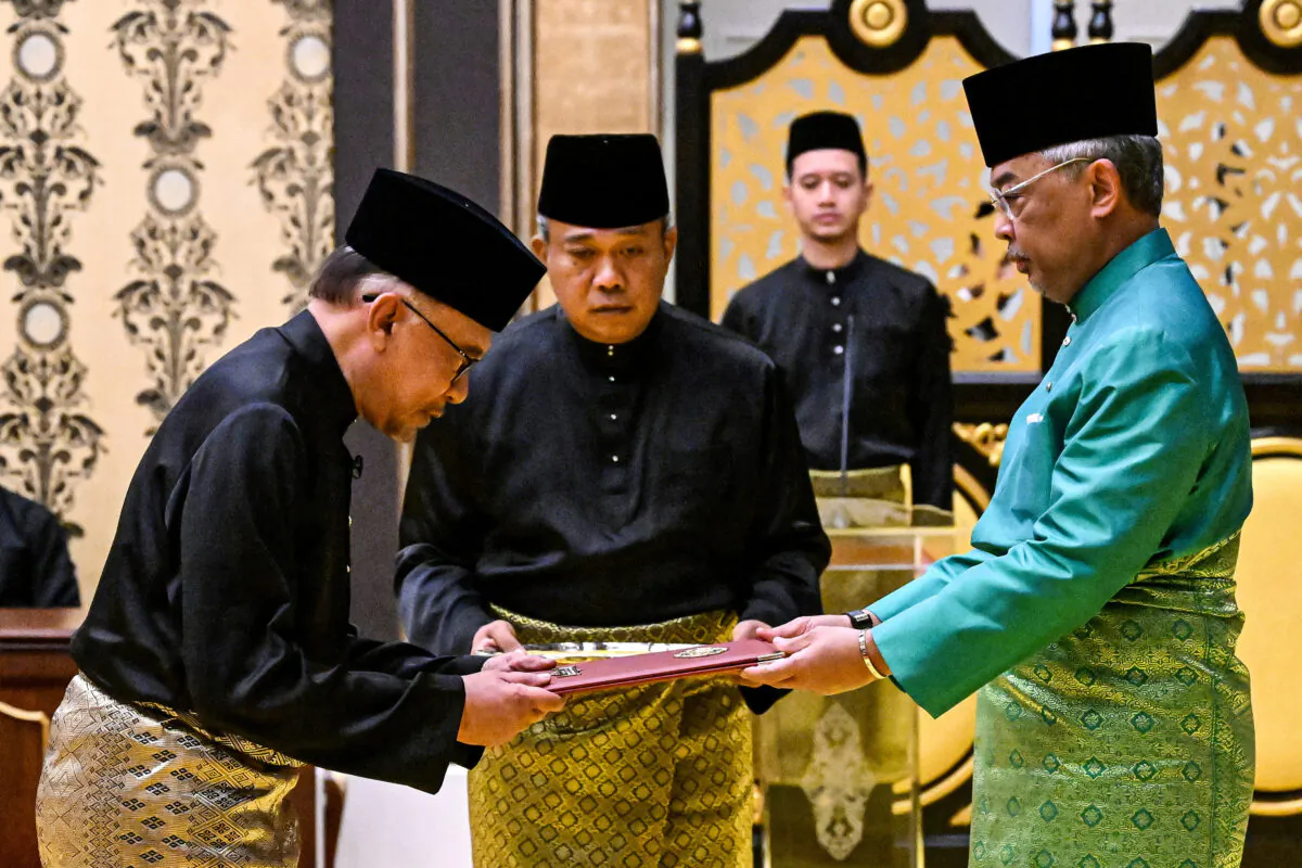 Malaysia's King Sultan Abdullah Sultan Ahmad Shah and Malaysia's newly appointed Prime Minister Anwar Ibrahim take part in the swearing-in ceremony at the National Palace in Kuala Lumpur, Malaysia, on Nov. 24, 2022. (Mohd Rasfan/Pool via Reuters)