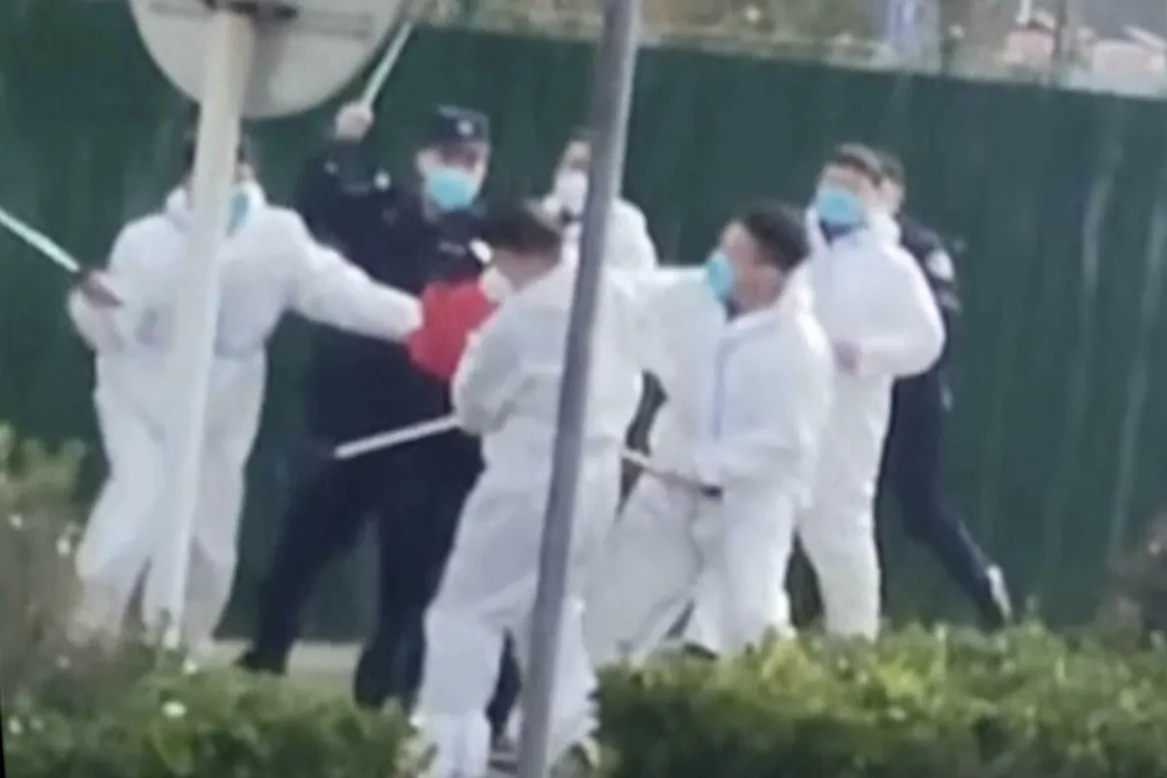 Security personnel in protective clothing attack a 
protester with clubs after he grabbed a metal pole that had been used to strike him during a protest at the factory compound operated by Foxconn Technology Group which runs the world’s biggest Apple iPhone factory in Zhengzhou in central China’s Henan Province on Nov. 23, 2022. (AP)