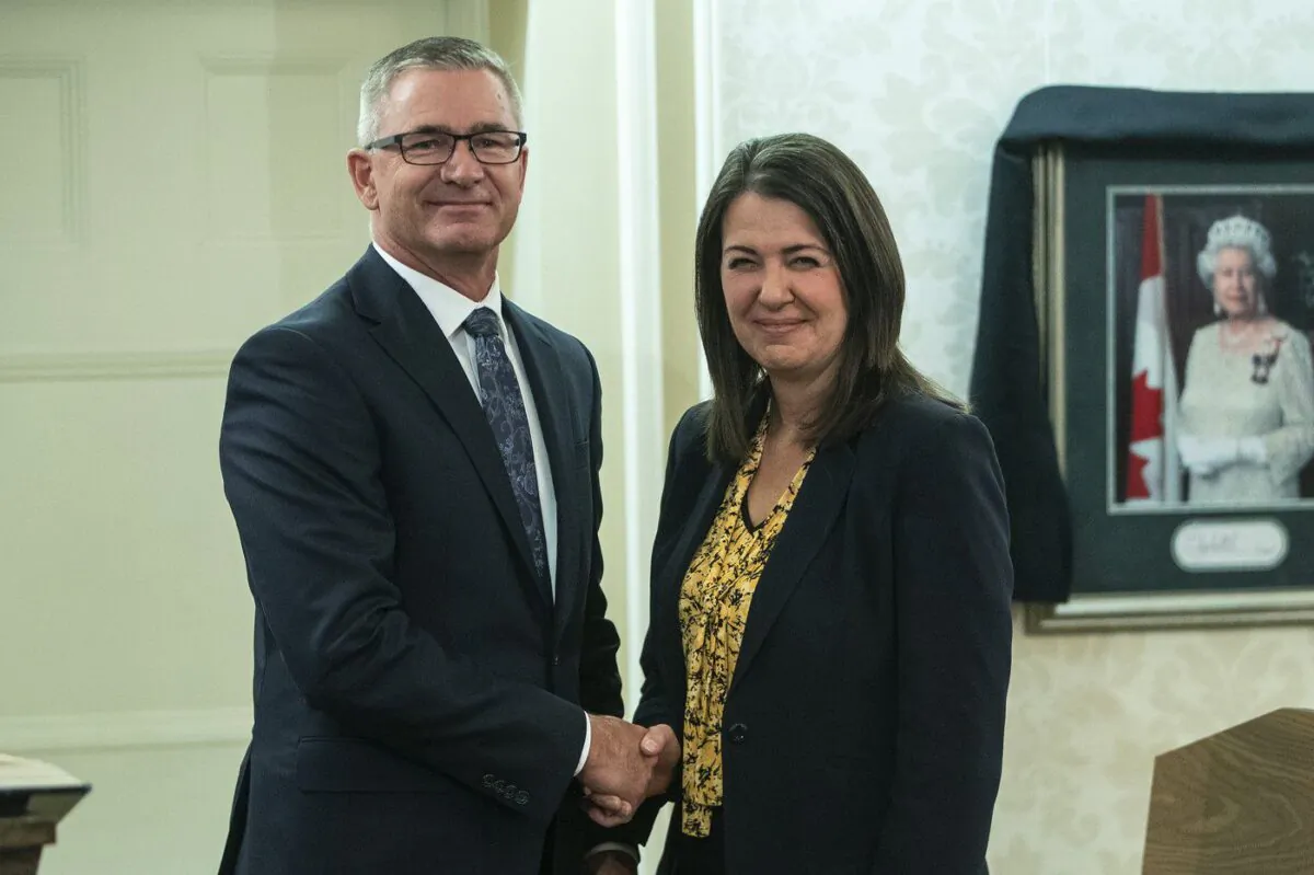 Travis Toews shakes hands with Alberta Premier Danielle Smith after he was sworn into cabinet as president of Treasury Board and minister of finance in Edmonton, on Oct. 24, 2022. (Jason Franson/The Canadian Press)