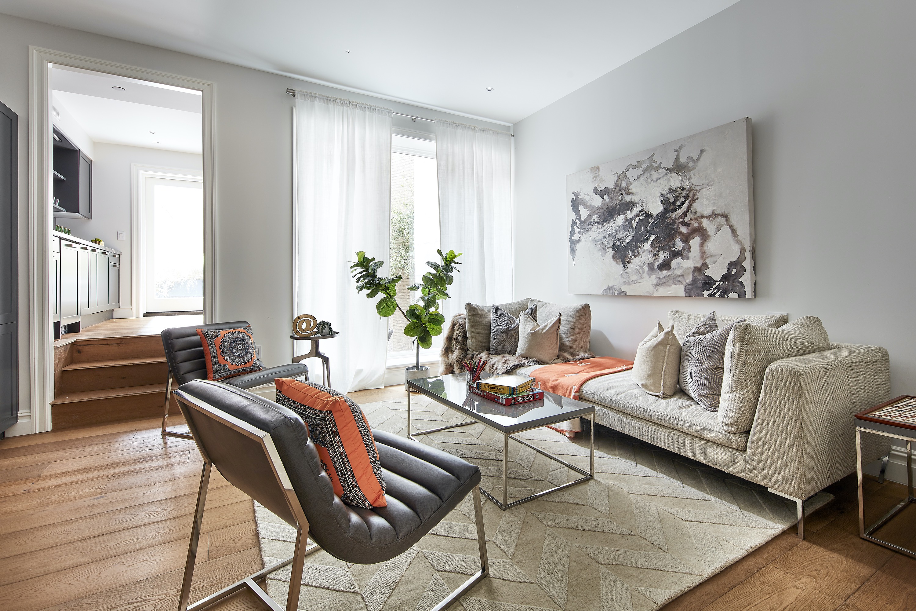 A neutral space is elevated through the use of pops of citrus orange.