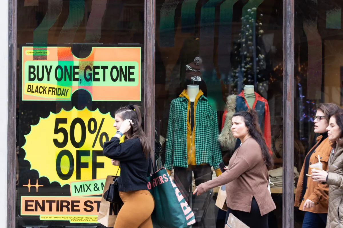Shoppers walk past sale signs in the outdoor shopping area of Avalon during Black Friday in Alpharetta, Ga., on Nov. 25, 2022. (Jessica McGowan/Getty Images)