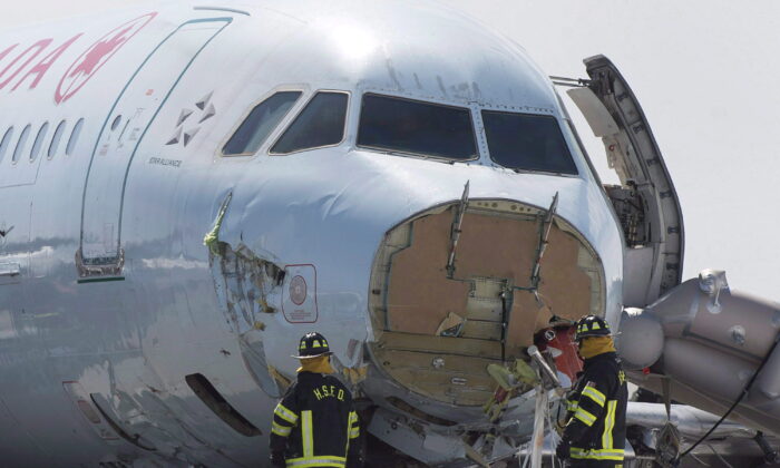 Airport firefighters work at the crash site of the Air Canada AC624 that crashed early Sunday morning during a snowstorm at Stanfield International Airport in Halifax on March 30, 2015.  (The Canadian Press/Andrew Vaughan)